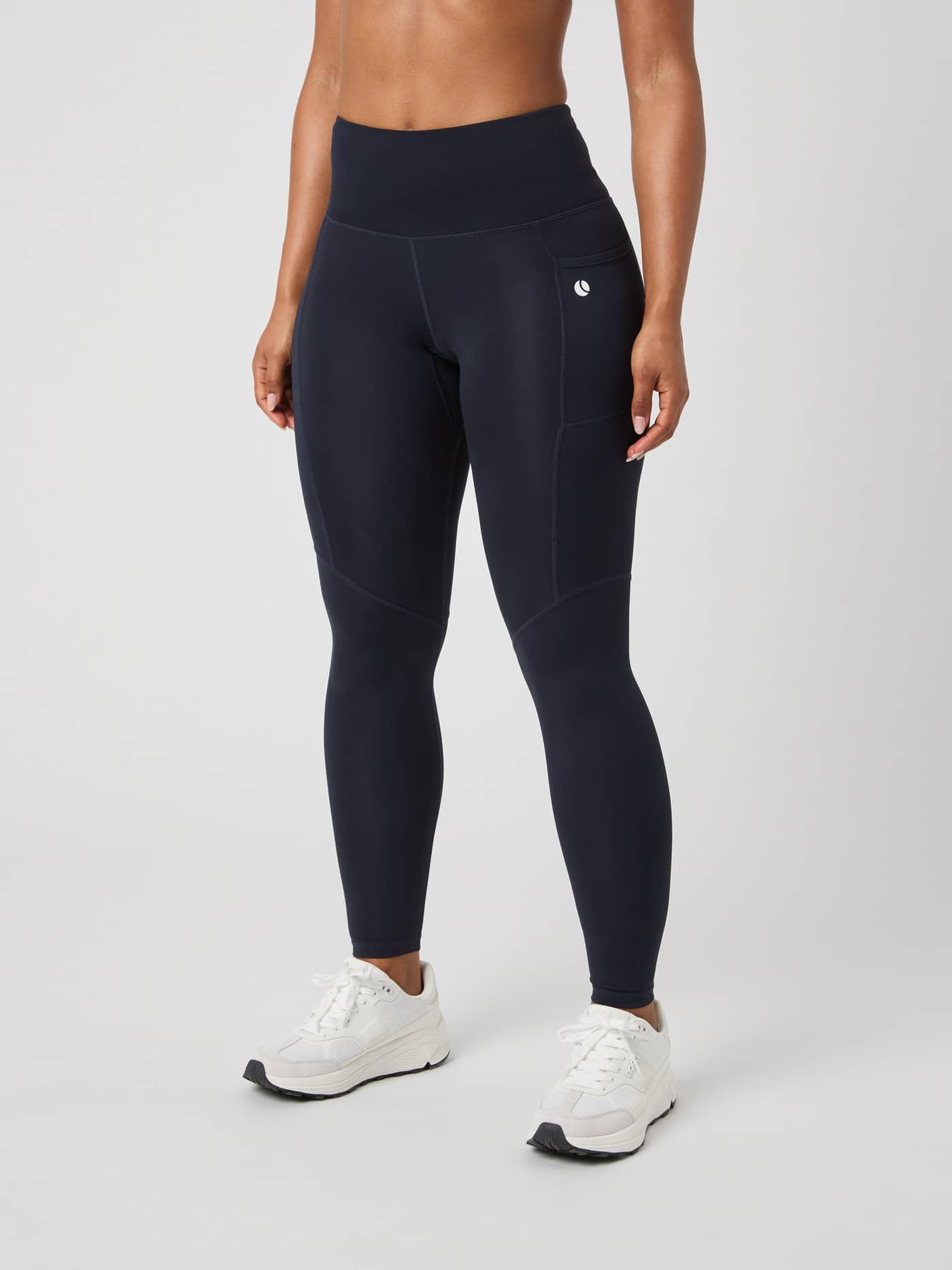 Front view of a model wearing Björn Borg Ace Pocket Tights in Night Sky (Navy) with a white tennis ball logo. - Image 1