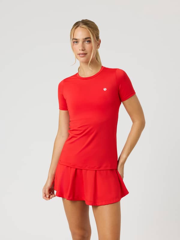 Front view of a model wearing the Ace Slim T-Shirt in Flame Scarlet (Red), a slim fit tennis tee for on-court performance.