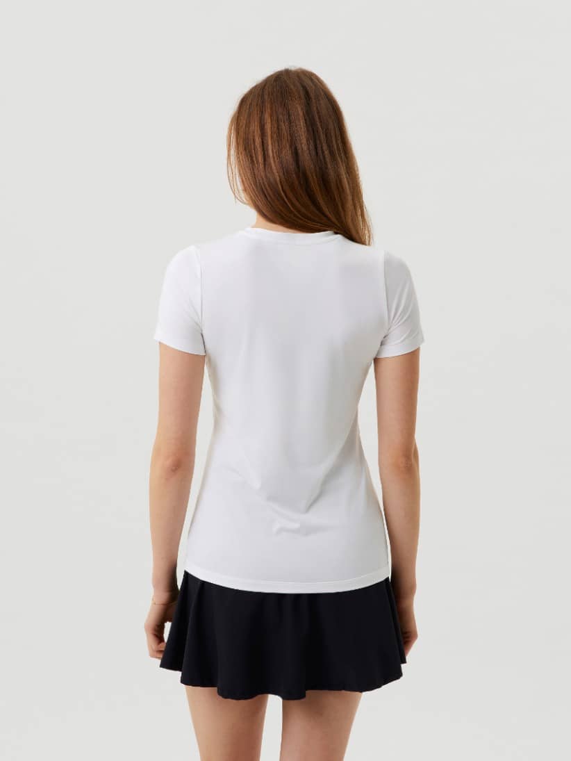 Vue de dos de l'Ace Slim T-Shirt en Brilliant White (Blanc), haut de tennis ajusté porté avec une jupe noire. - Image 2