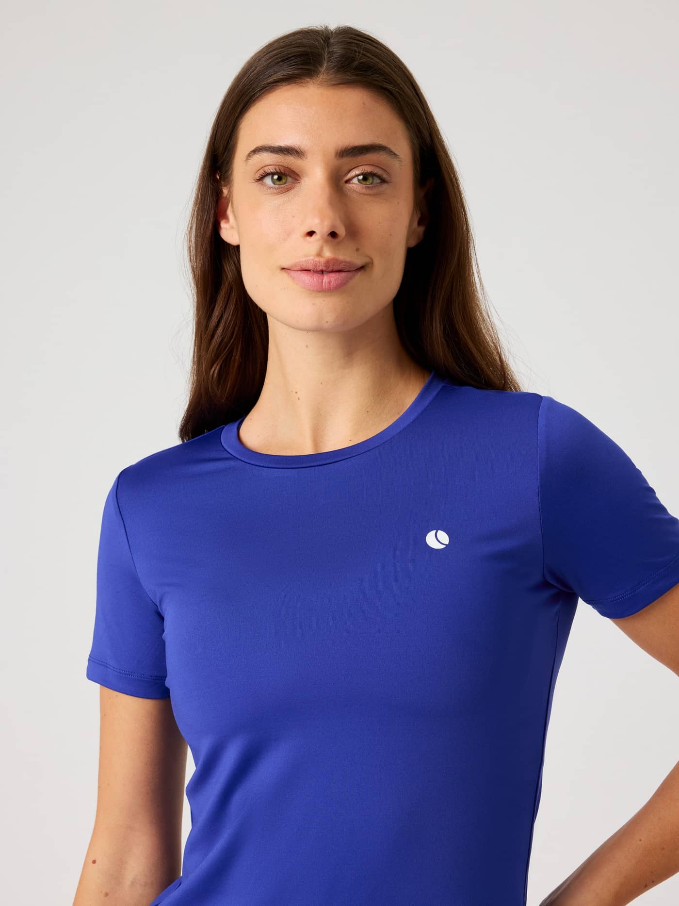 Front view of a woman wearing the Björn Borg Ace Slim T-Shirt in Clematis Blue (Blue) featuring a white tennis logo. - Image 4