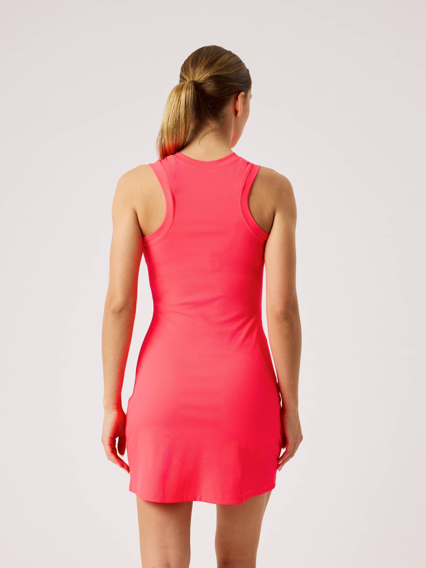 Ace Ribbed Dress in Diva Pink (Roze) met een slanke pasvorm en racerback voor tennis, getoond in achteraanzicht. - Image 2