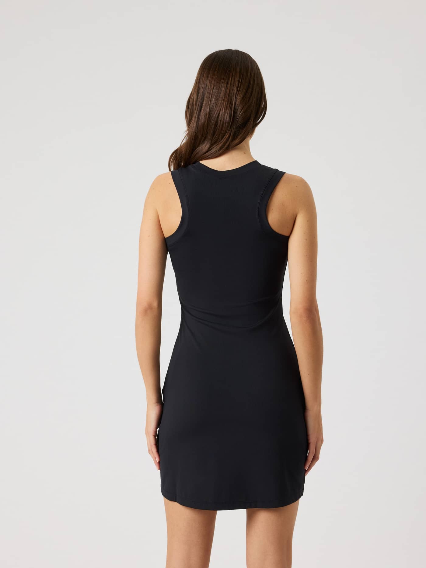 Achteraanzicht van de Ace Ribbed Dress in Black Beauty (Zwart) met een slanke pasvorm en racerback voor tennisprestaties. - Image 2