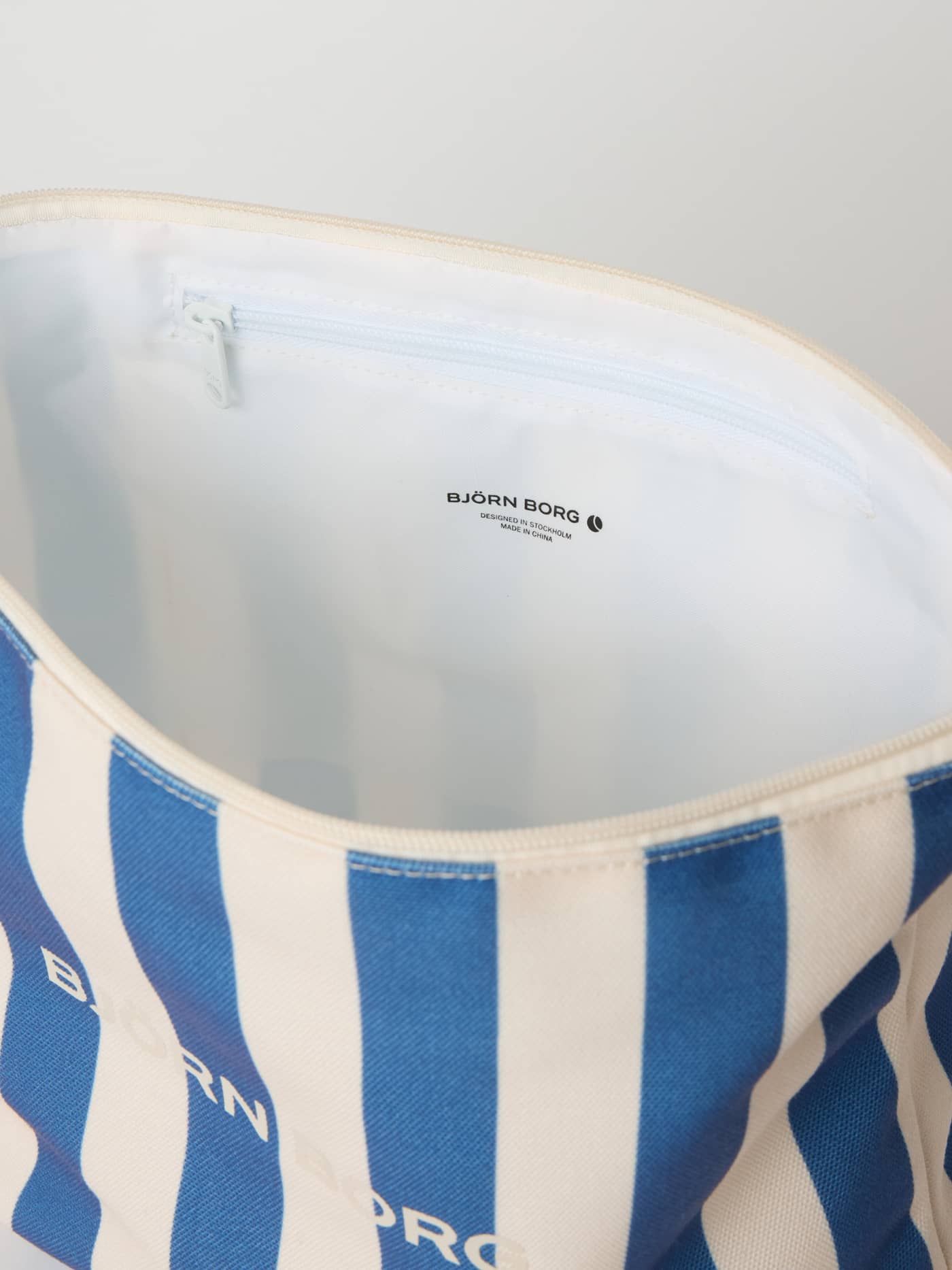 Intérieur de la trousse de toilette Borg Beach Wash Bag rayée Coastal Fjord (Bleu) en polyester recyclé avec poche zippée. - Image 4