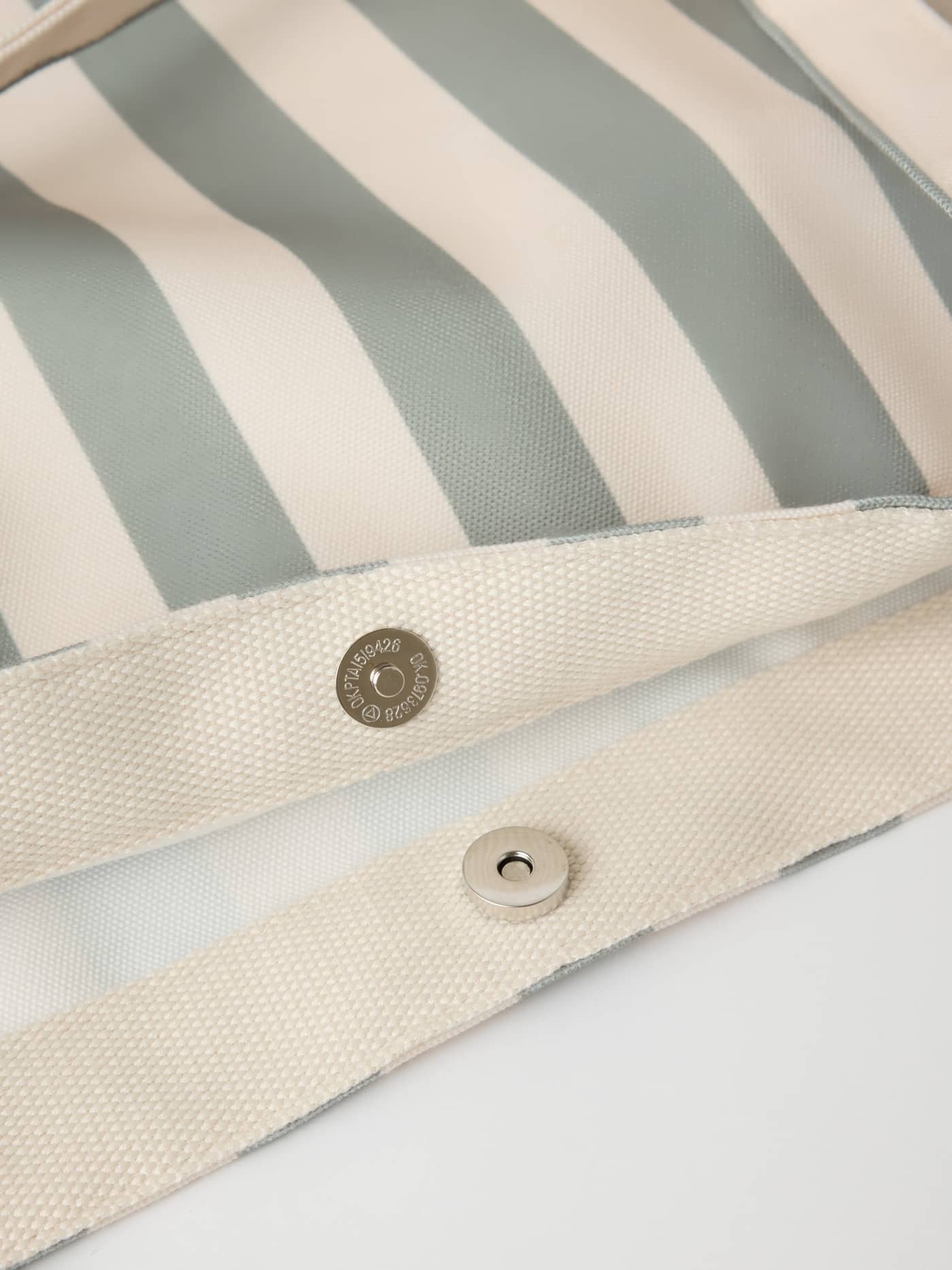 Detail van de magnetische knoopsluiting en het streeppatroon op de Borg Beach Tote M - 27L in Slate Gray (Groen). - Image 6