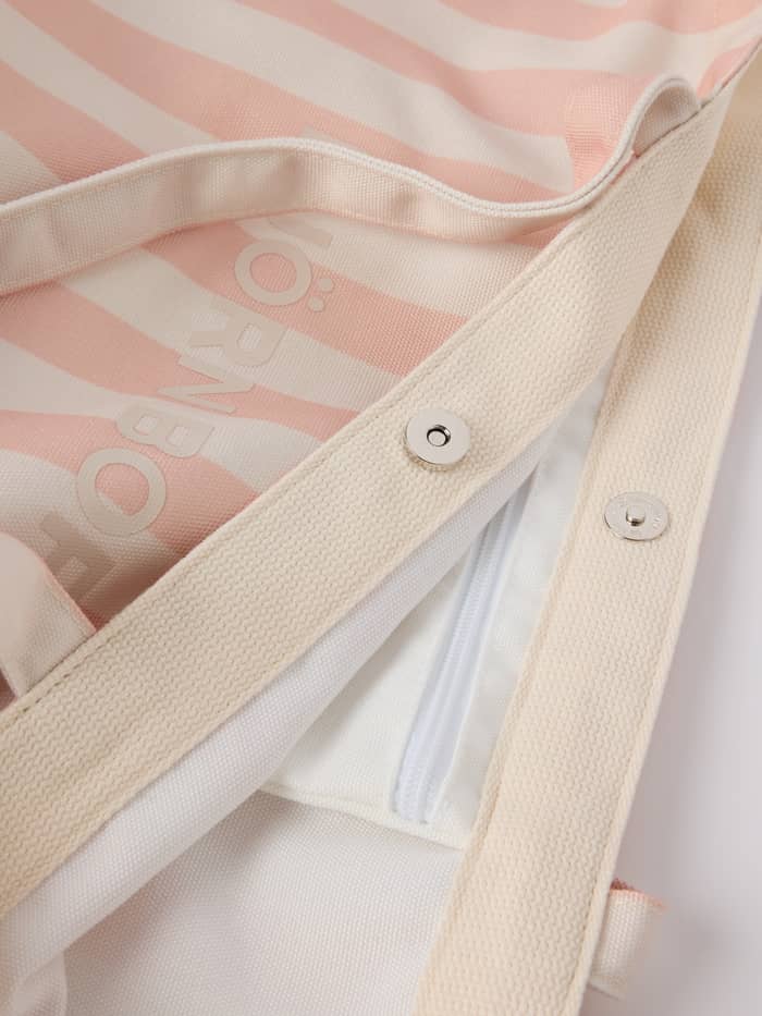 Close-up of the magnetic closure and striped recycled polyester fabric on the Borg Beach Tote M - 27L in Rose Cloud (Pink).