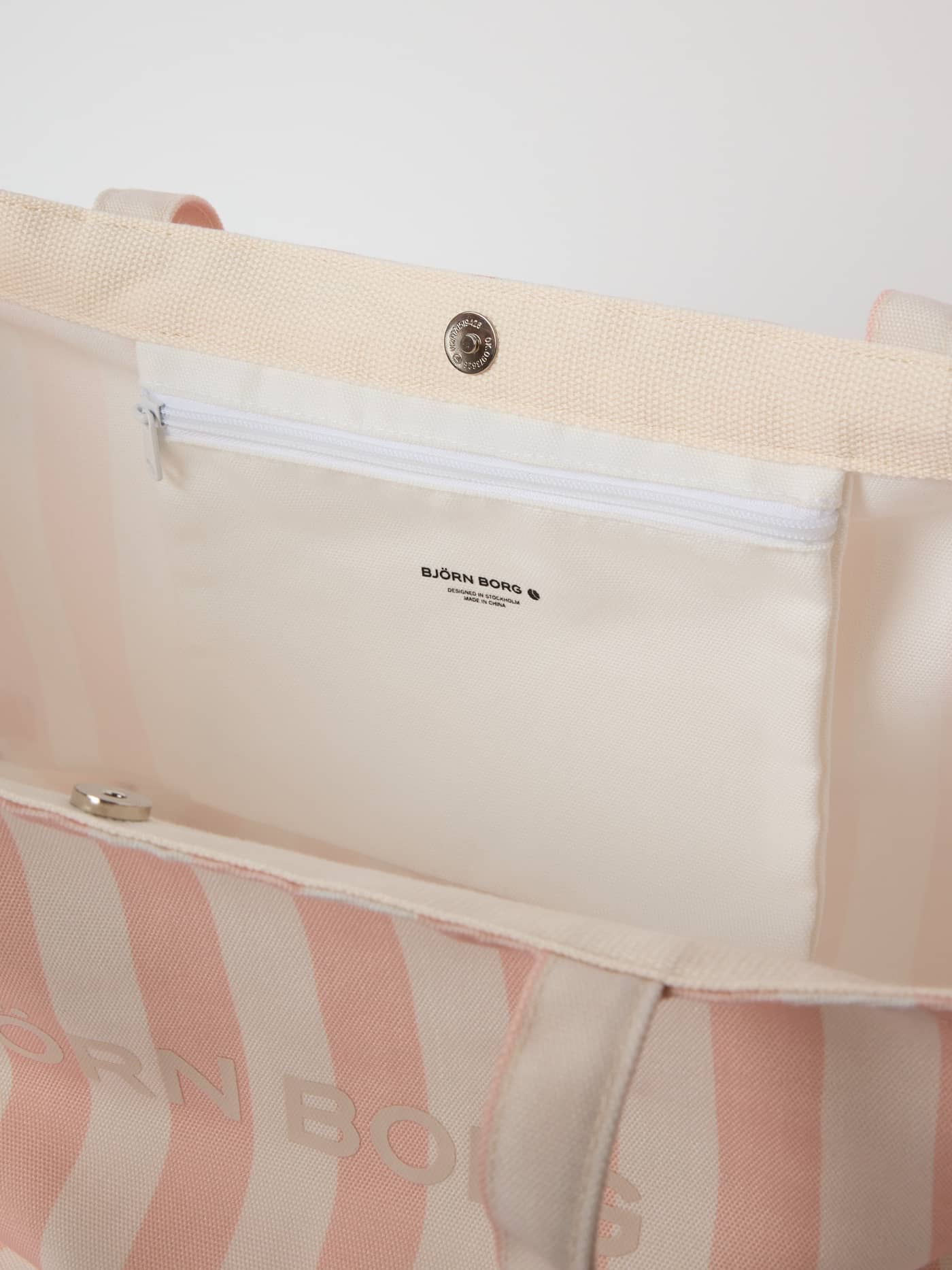 Interior of the striped Borg Beach Tote M - 27L in Rose Cloud (Pink) showing the zippered pocket and black logo. - Image 2
