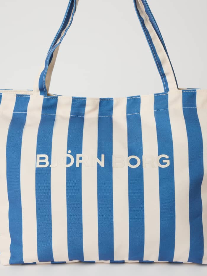 Front view of the striped Borg Beach Tote M - 27L in Coastal Fjord (Blue) featuring a white Björn Borg logo.