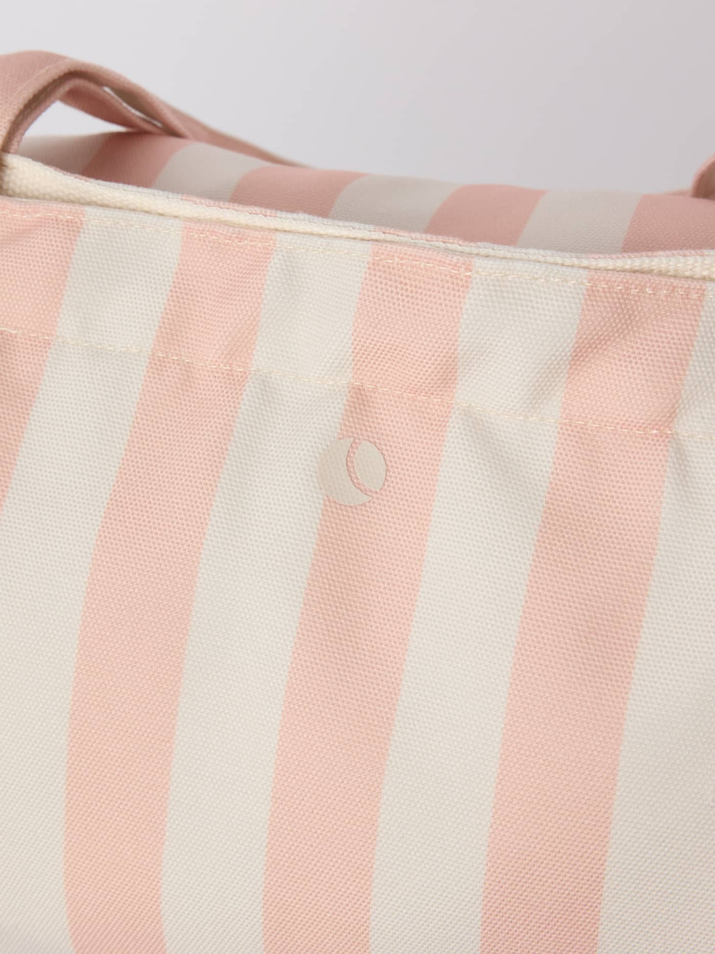Close-up of the striped Borg Beach Tote M - 27L in Rose Cloud (Pink), highlighting the durable fabric and white logo. - Image 6