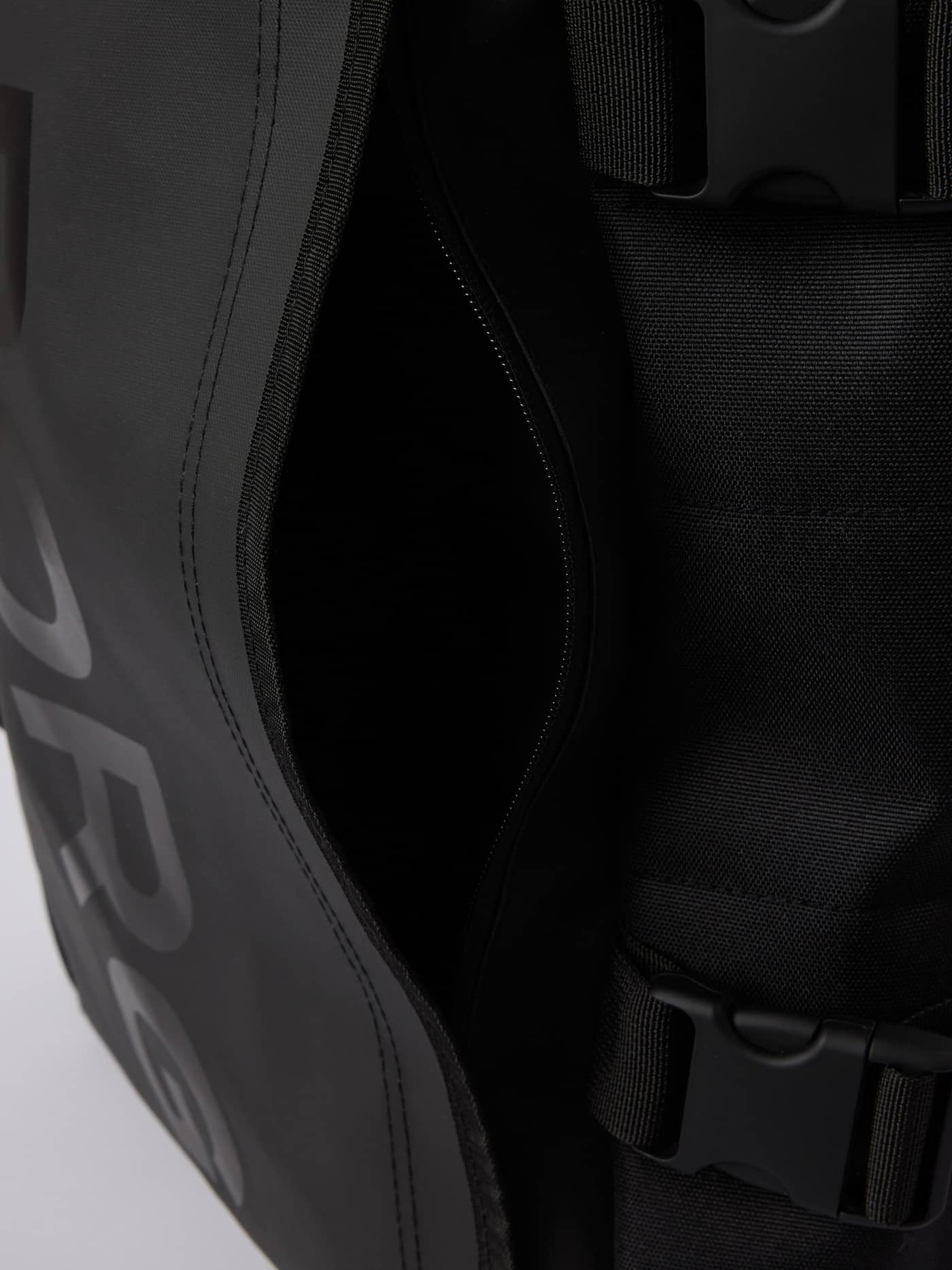 Travel Backpack M - 22L i Black Beauty (Sort) set tæt på med fokus på det slidstærke TPE-belagte materiale. - Image 5