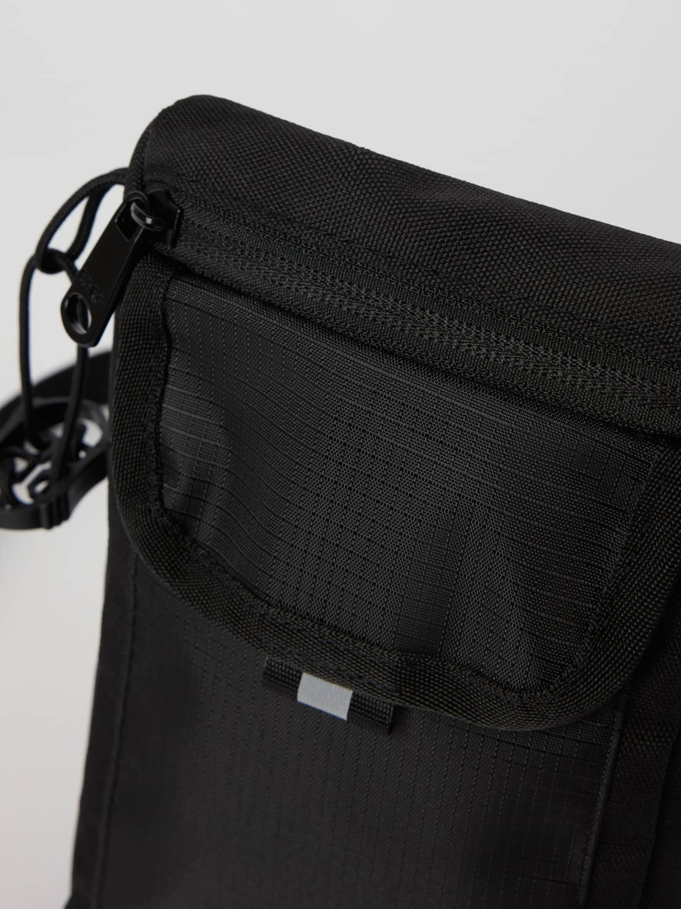 Detailed close-up of the Björn Borg Crossover Bag S in Black Beauty (Black), highlighting its durable material and zipper. - Image 4