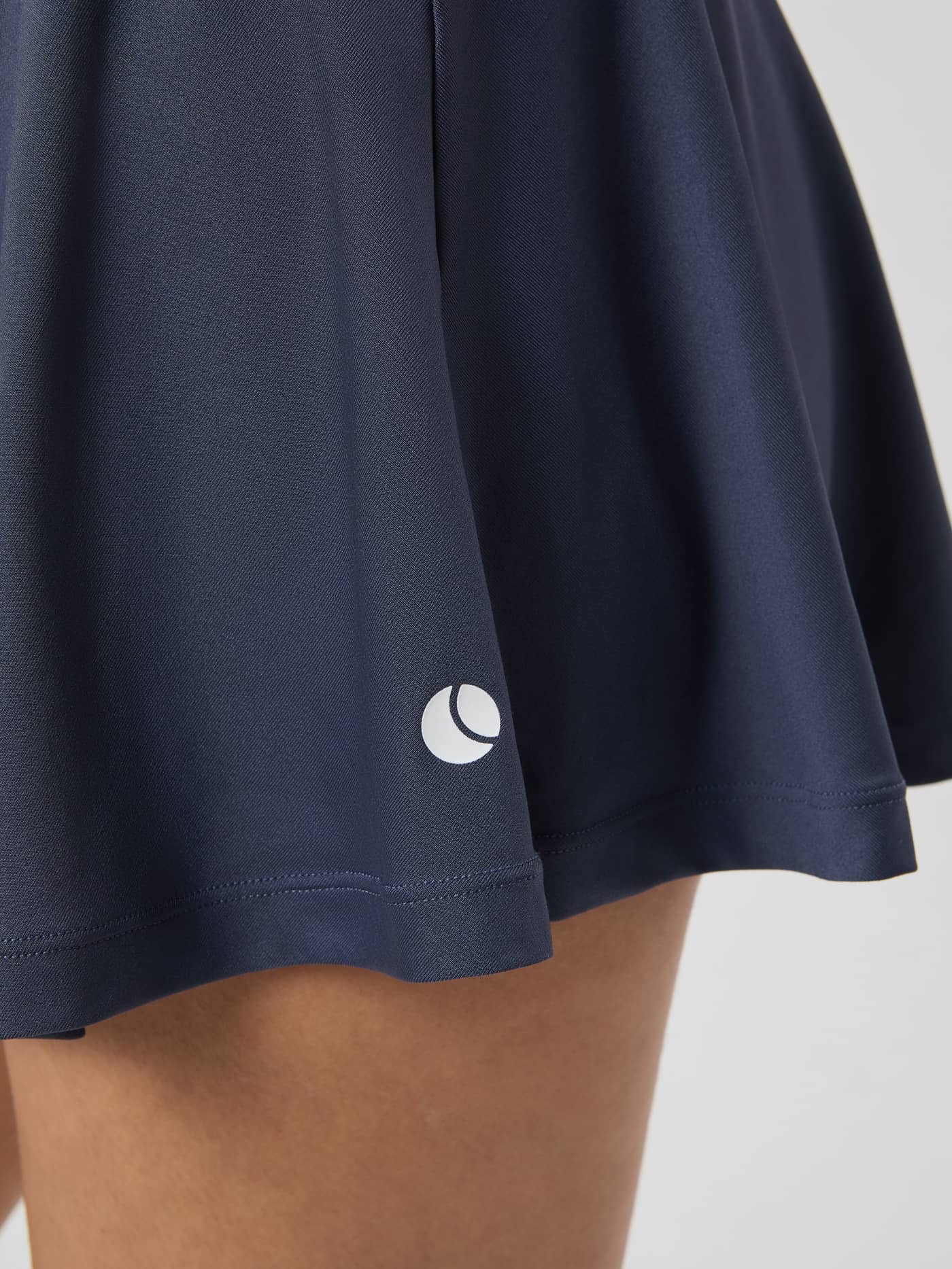 Close-up of the Björn Borg Ace Jersey Skirt in Odyssey Gray, showing the logo on the hem. - Image 2