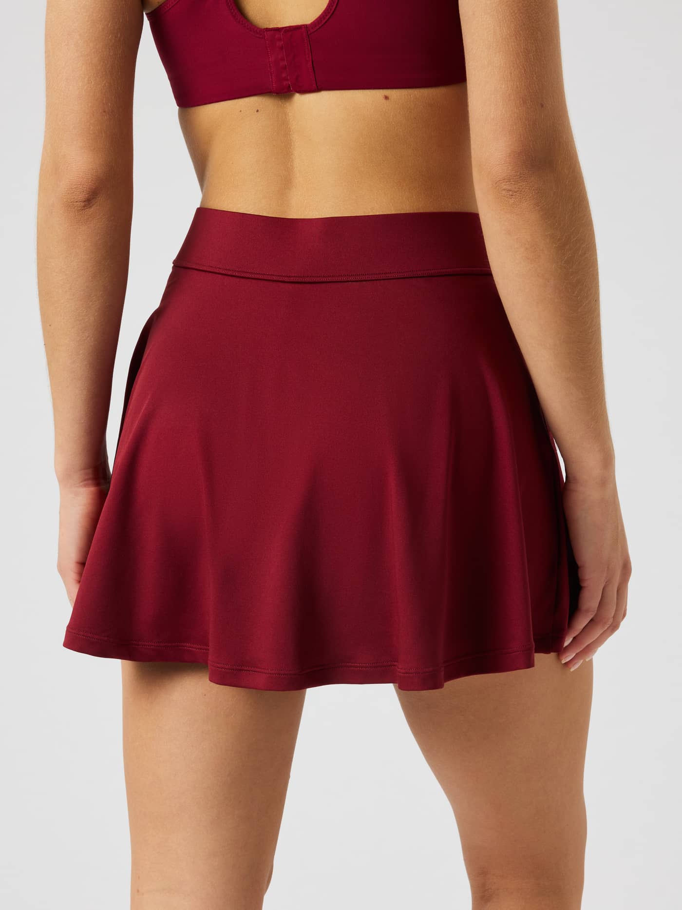 Achterkant van de Ace Jersey Skirt in Cabernet (rood) met een normale taille en korte lengte. - Image 3