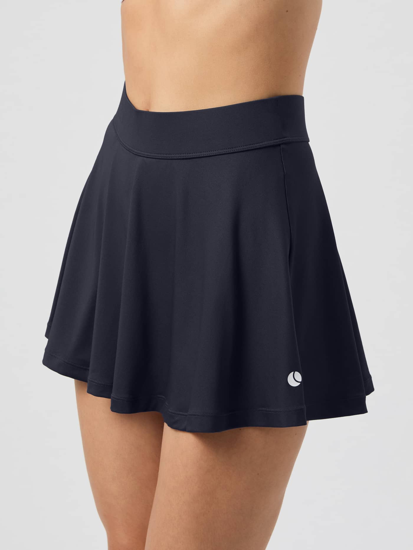 Side view of a model wearing the navy Björn Borg Ace Jersey Skirt. - Image 1