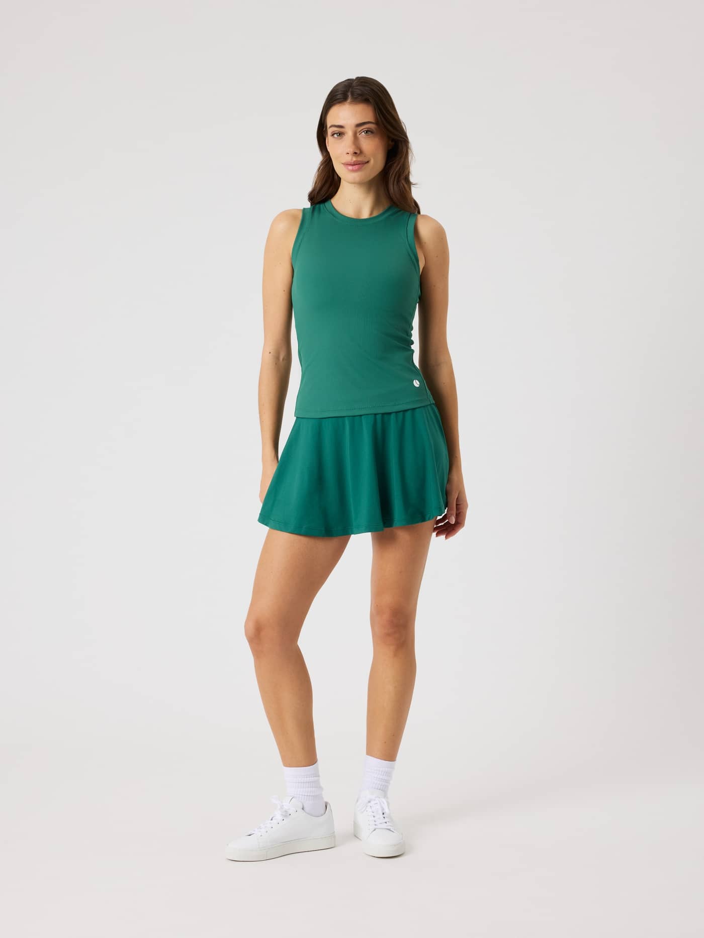 Ace Jersey Skirt i Posy Green (Grøn) set forfra på en kvinde, designet i et blødt ribstof ideelt til tennis. - Image 3