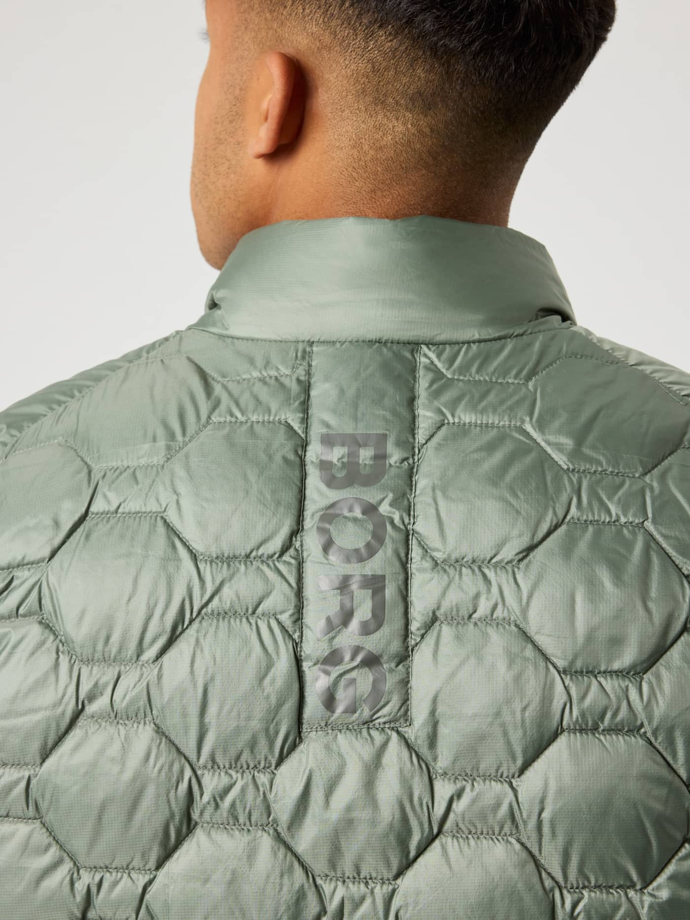 Närbild bakifrån på Borg Down Liner Vest i Agave Green (Grön) för herrar med en grå vertikal logorand. - Image 5