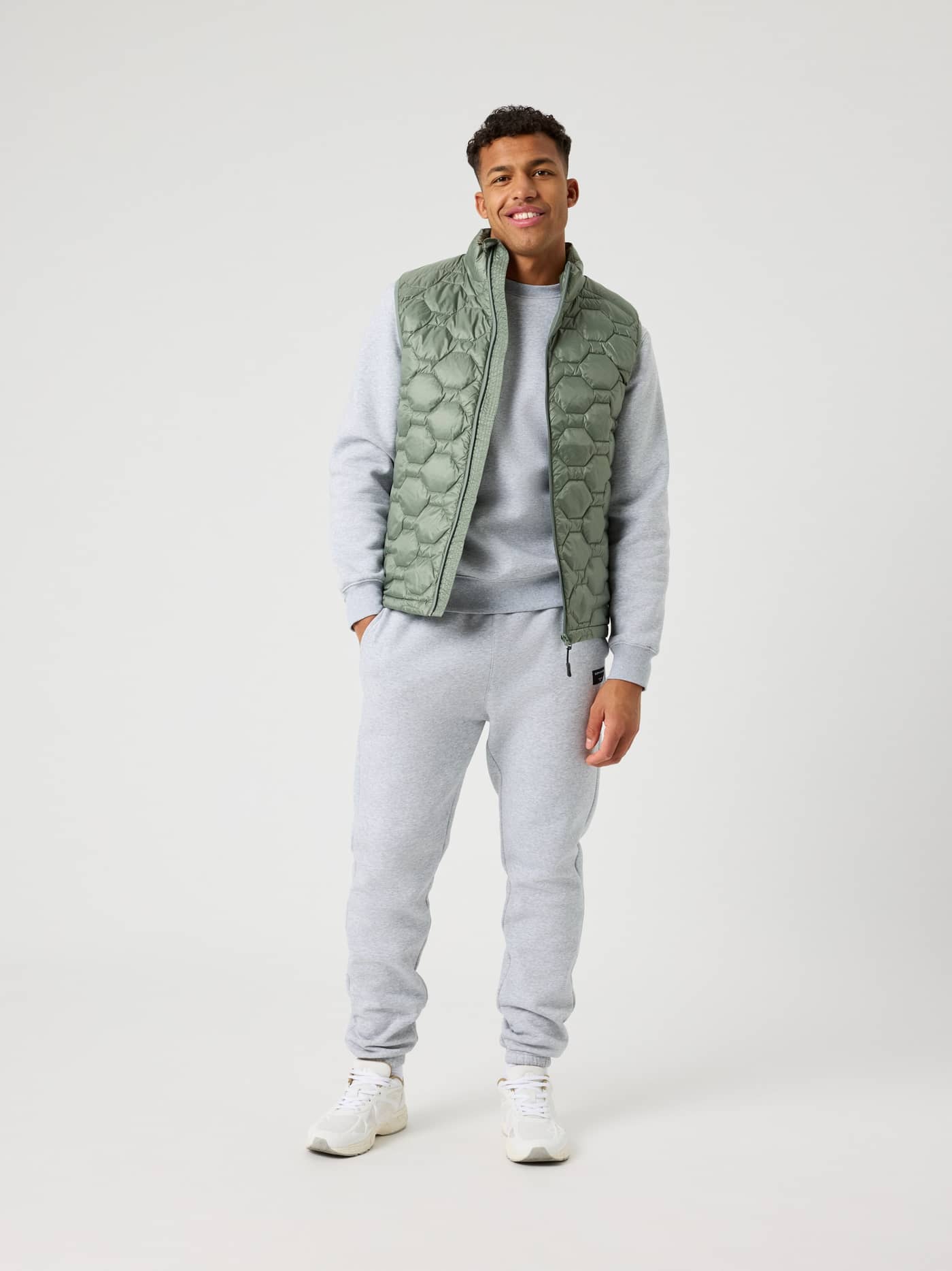 Borg Down Liner Vest i Agave Green (Grön) sedd framifrån i helfigur på en man i grå tracksuit, stilren och funktionell. - Image 2