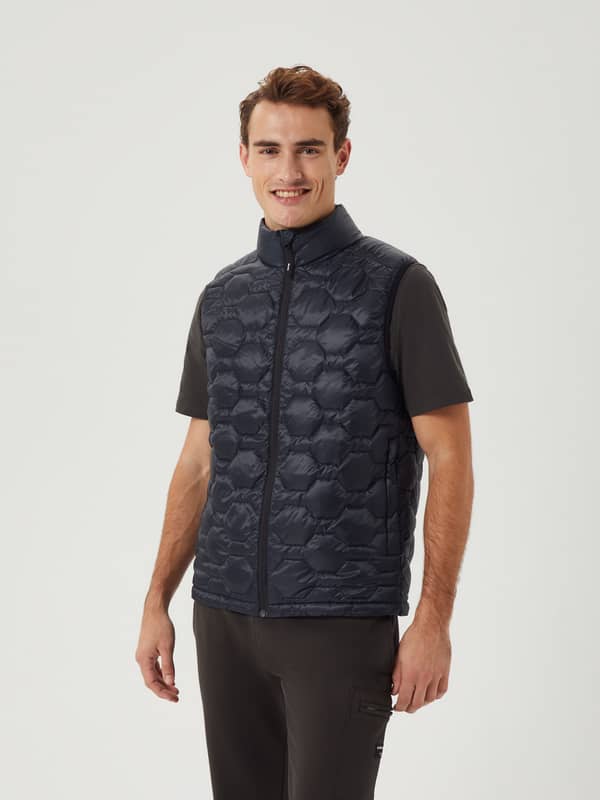 Modell framifrån i kviltad Borg Down Liner Vest i Black Beauty (Svart) för stilren och funktionell lager-på-lager-look.