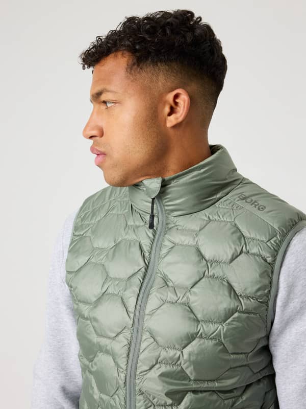 Borg Down Liner Vest i Agave Green (Grön) sedd i profilvy med sexkantig kviltning och en grå axellogotyp.