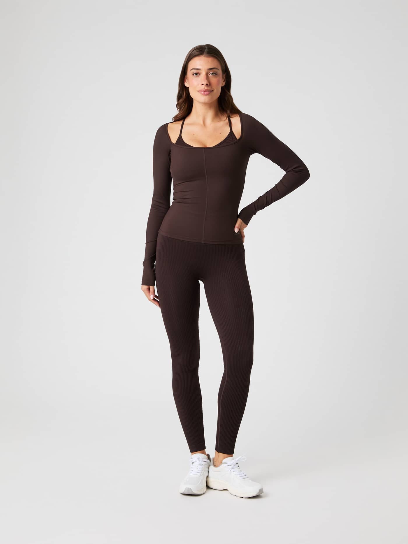 Full-body front view of a woman in the slim-fit Björn Borg Studio Ballerina Long Sleeve training top in Molé (Brown). - Image 4