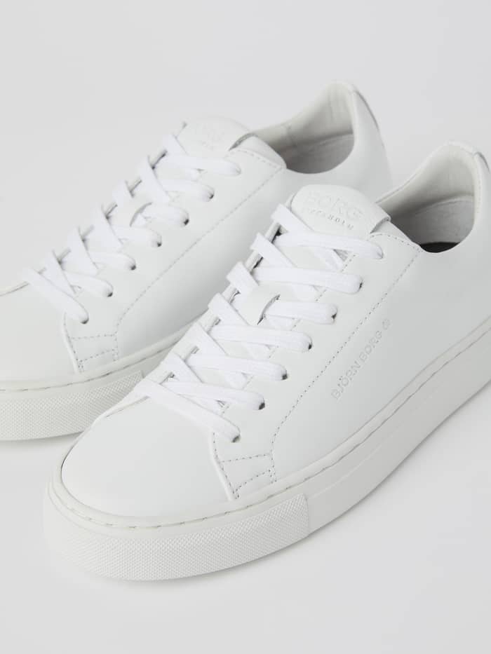 Gros plan des Men’s Classic Leather sneakers en cuir de vache Blanc avec un logo argenté subtil. - Image 3