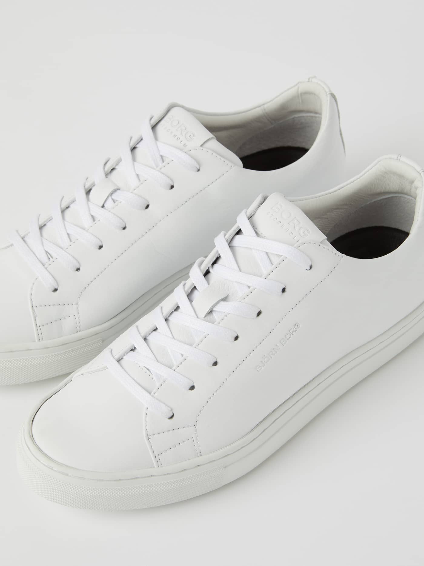 Detailed view of the white Women's Classic Leather Sneakers, a tennis-inspired leather shoe with subtle tonal logo details. - Image 3
