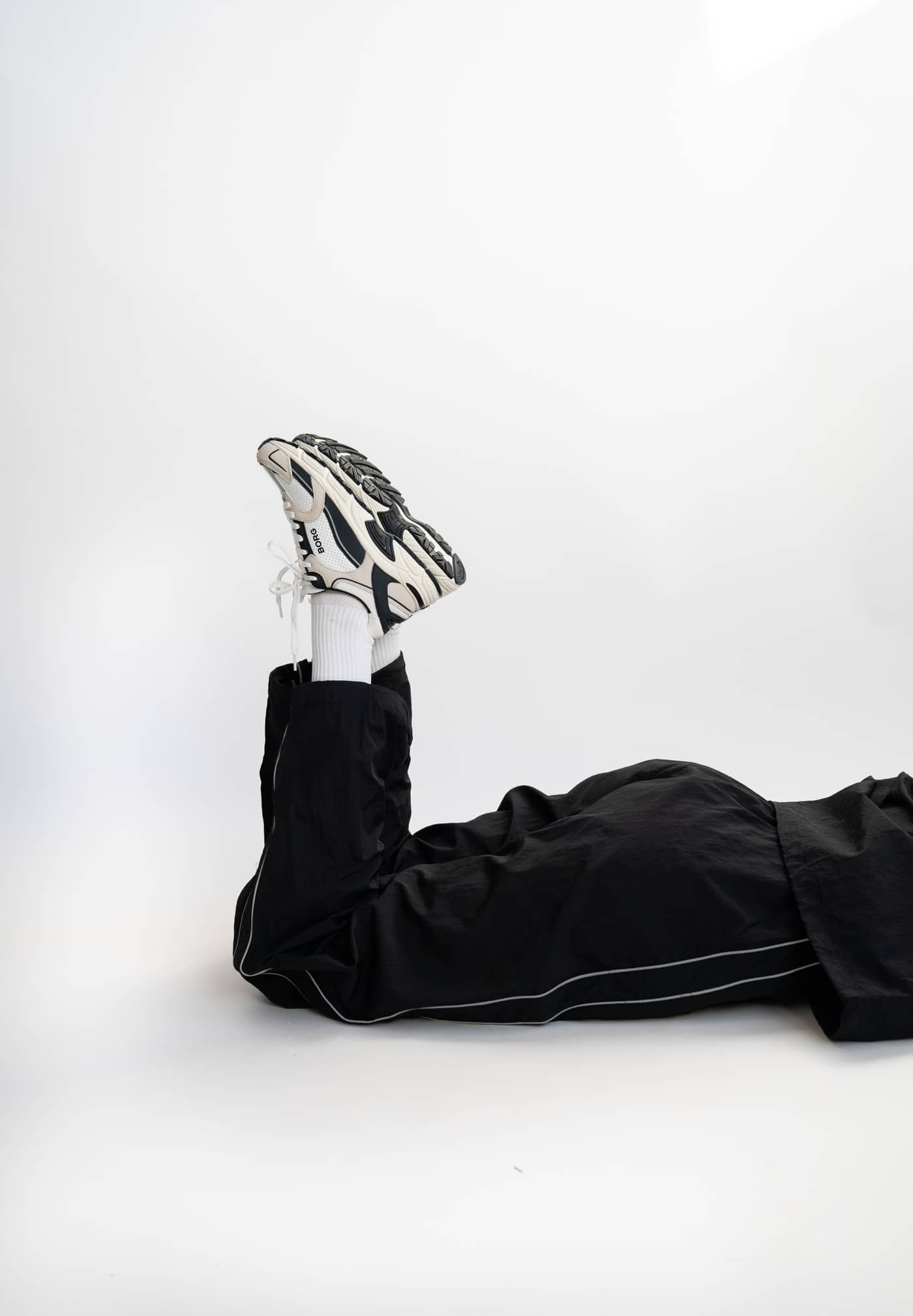 Side profile of the Women's Alley Sneakers in White leather, featuring a black logo and running-inspired style. - Image 2