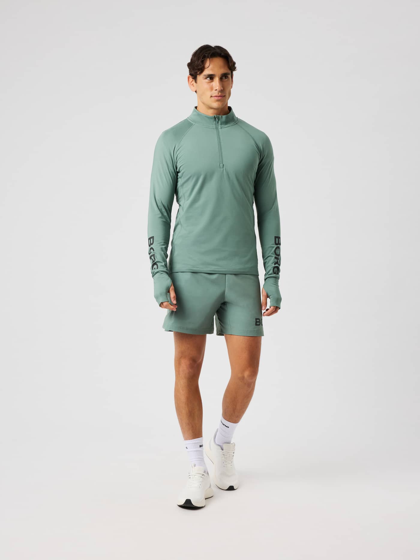 Front view of the Borg Midlayer Half Zip in laurel wreath (green) with a half-zip and black logo prints for training. - Image 4
