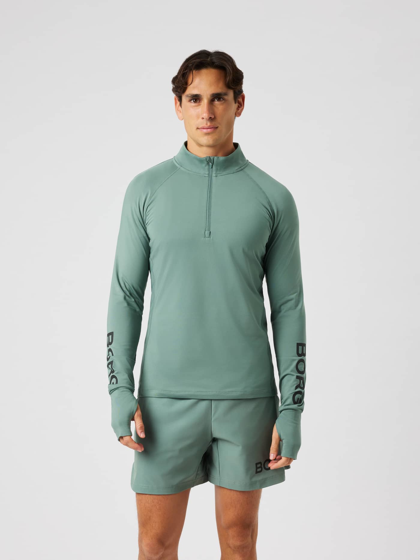 Male model wearing the Borg Midlayer Half Zip in laurel wreath for training, featuring a half-zip and thumb hole openings. - Image 2