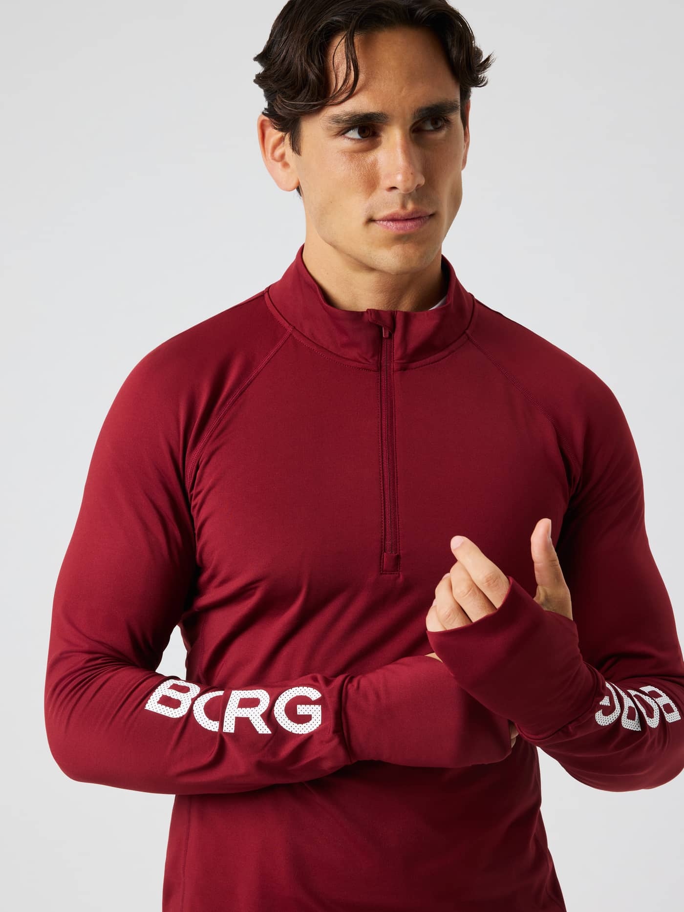 Close-up of the Borg Midlayer Half Zip in Cabernet (Red) featuring a half-zip front and white logo prints for training. - Image 1