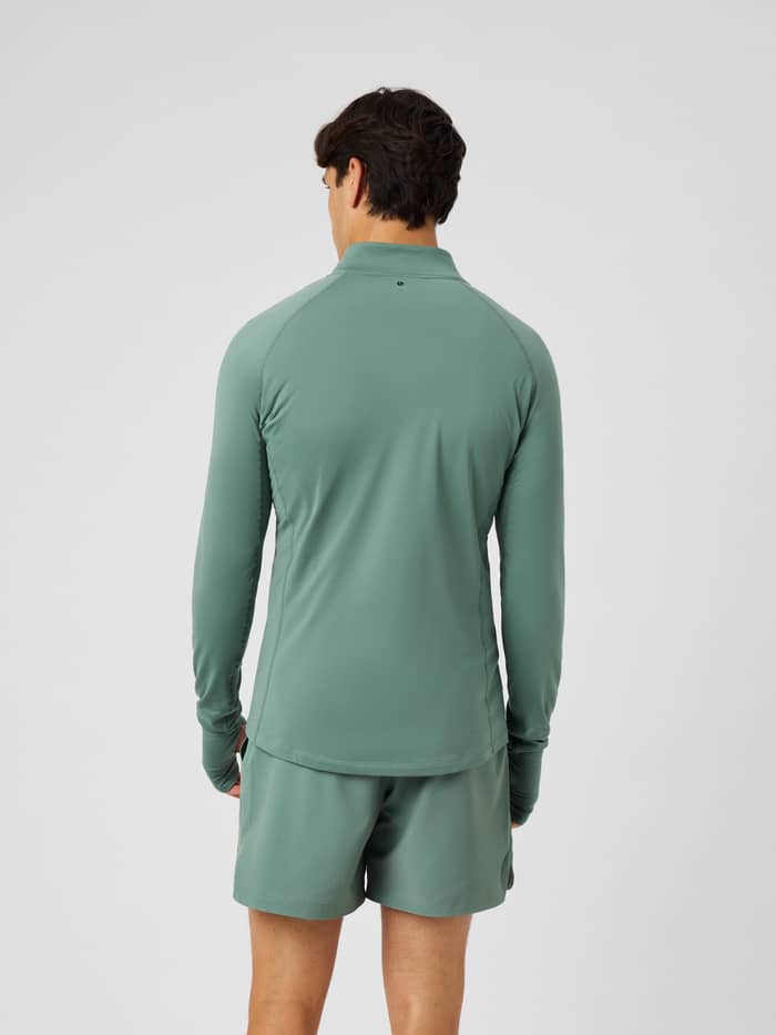 Back view of the Borg Midlayer Half Zip in Laurel Wreath (green) for training, featuring raglan sleeves with thumb holes.