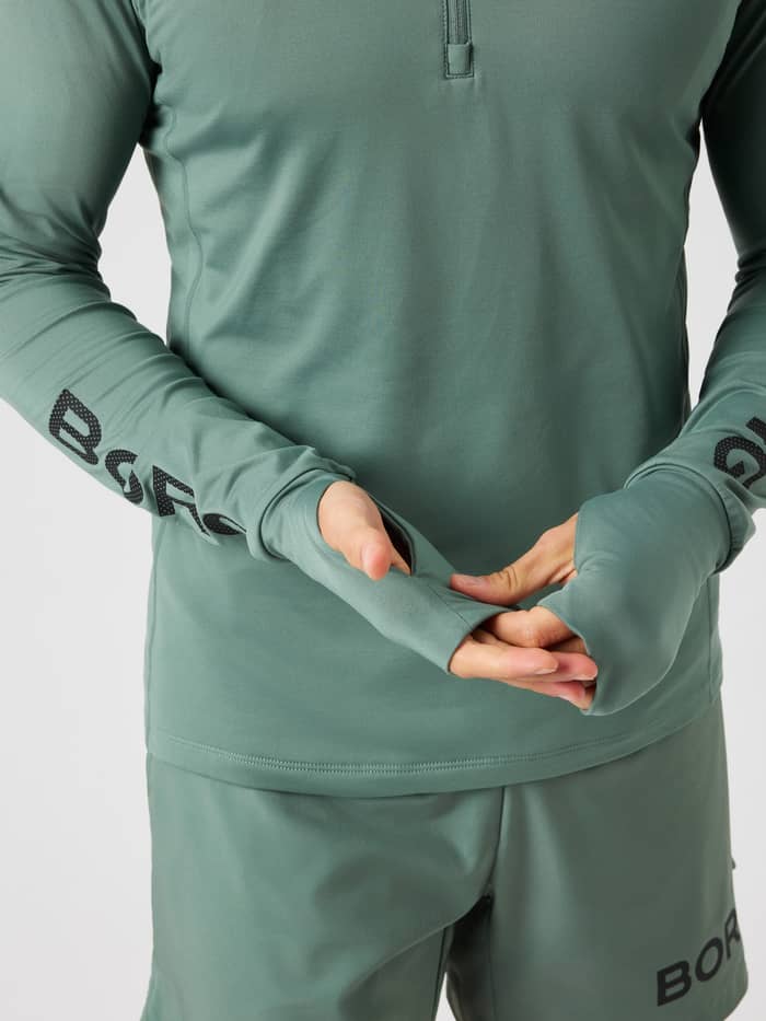 Borg Midlayer Half Zip in Laurel Wreath (Green) highlighting thumb holes and BORG arm logo for training.