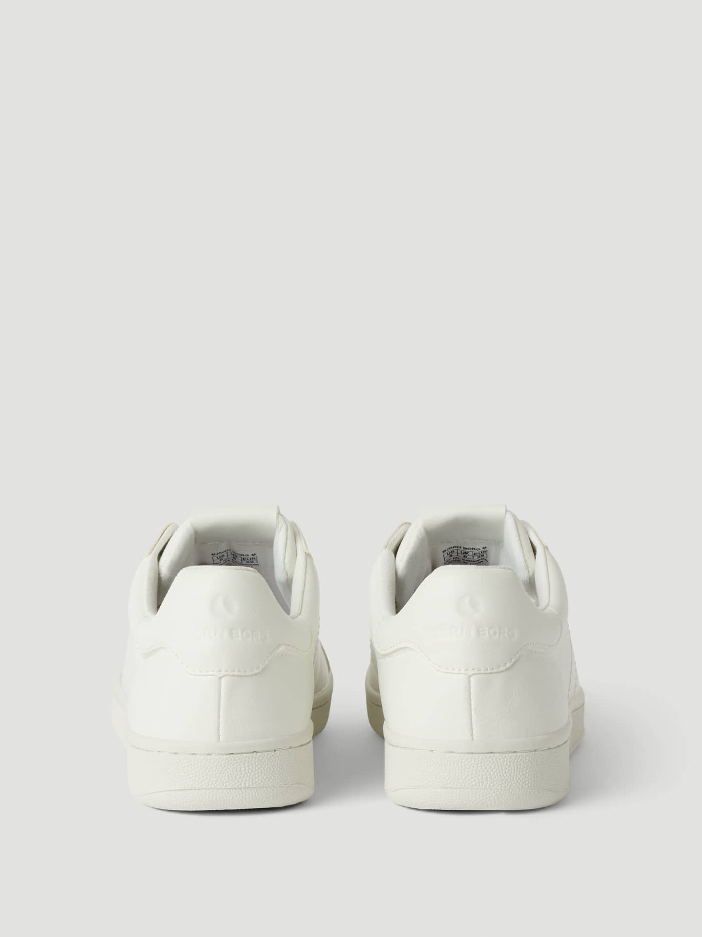 Vista posterior de las Women's Deuce Sneakers (T305) en blanco de piel sintética con el logotipo de pelota de tenis. - Image 3