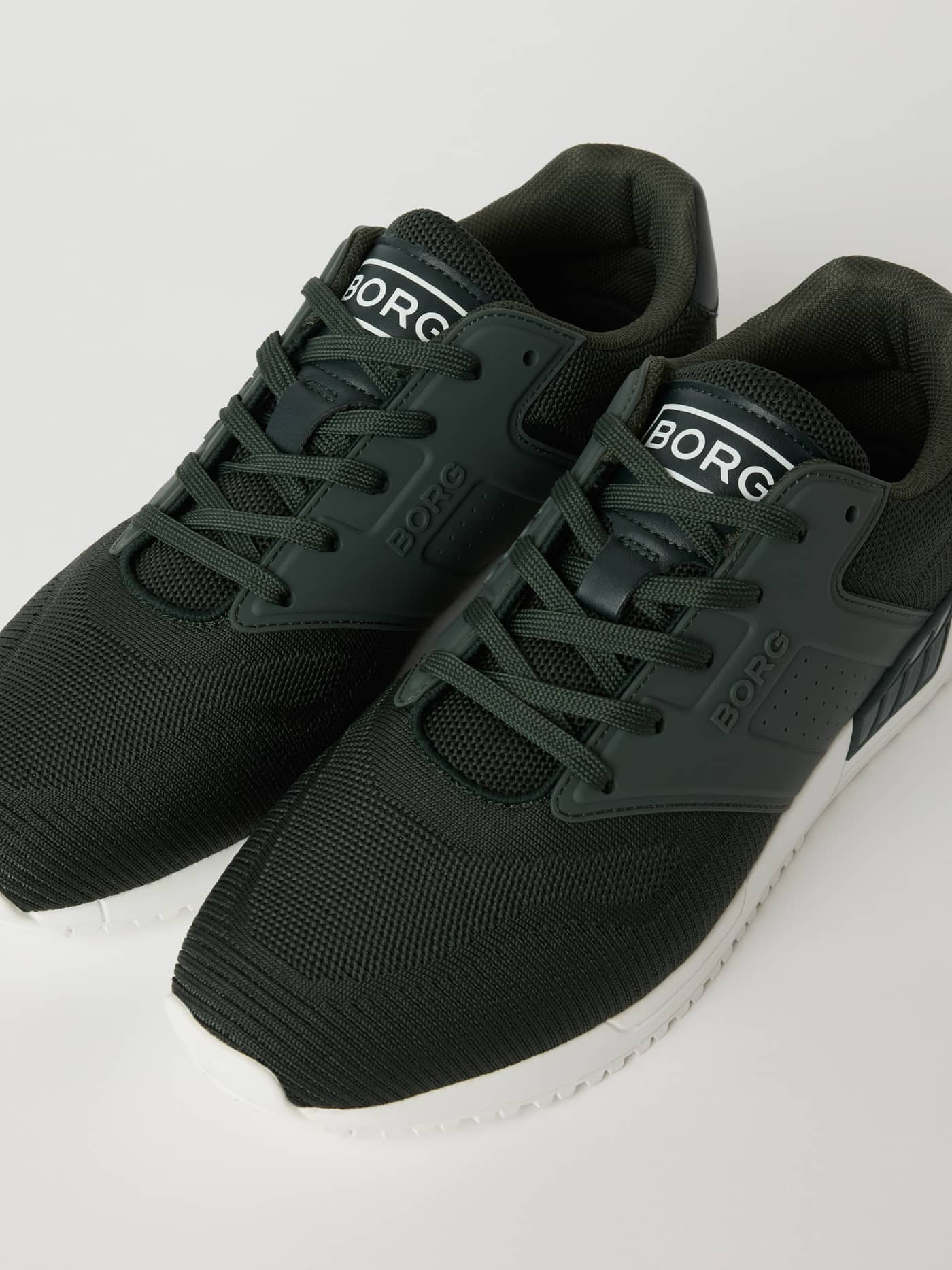Vue inclinée des Men’s sneakers R140 Knit vert en maille respirante avec logo blanc pour le running. - Image 2