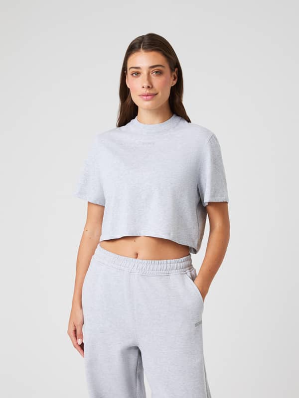 Front view of a woman in the soft Studio Oversized Cropped T-Shirt in Light Grey Melange (Grey), ideal for training.