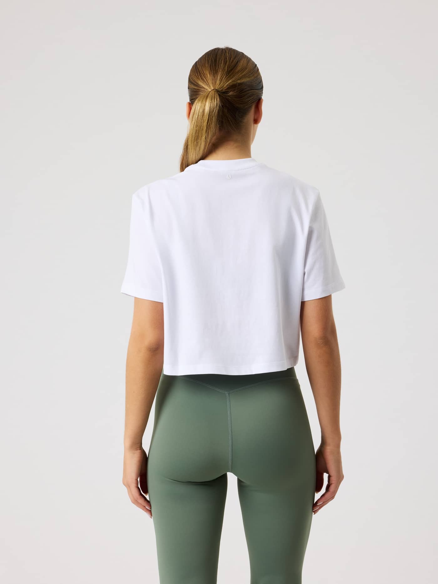 Back view of a model wearing the cotton Studio Oversized Cropped T-Shirt in Brilliant White (White) for stylish training. - Image 2