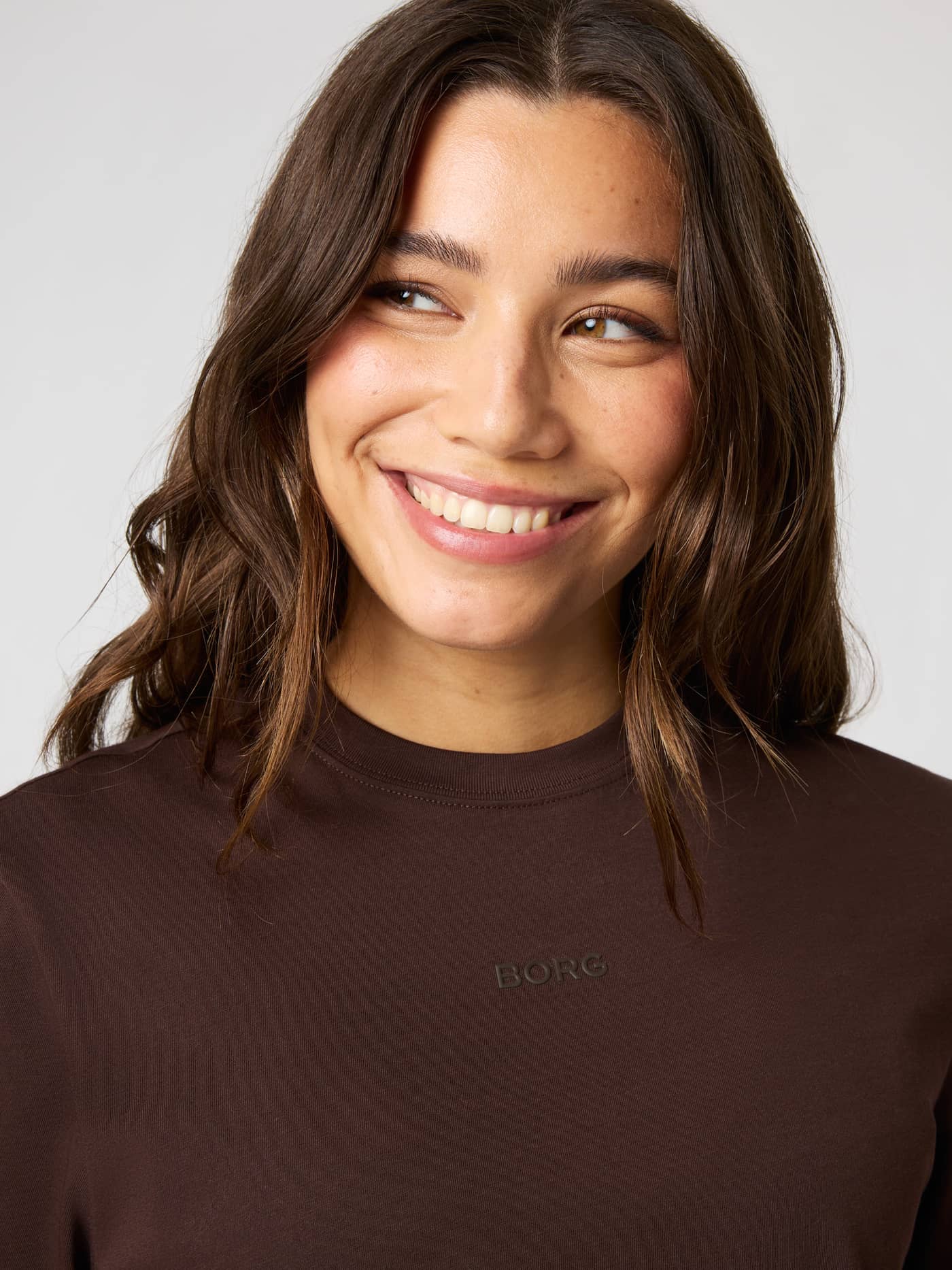 Close-up of the Studio Oversized Cropped T-Shirt in Coffee Bean (Brown) showing the subtle Borg logo and high round neck. - Image 3