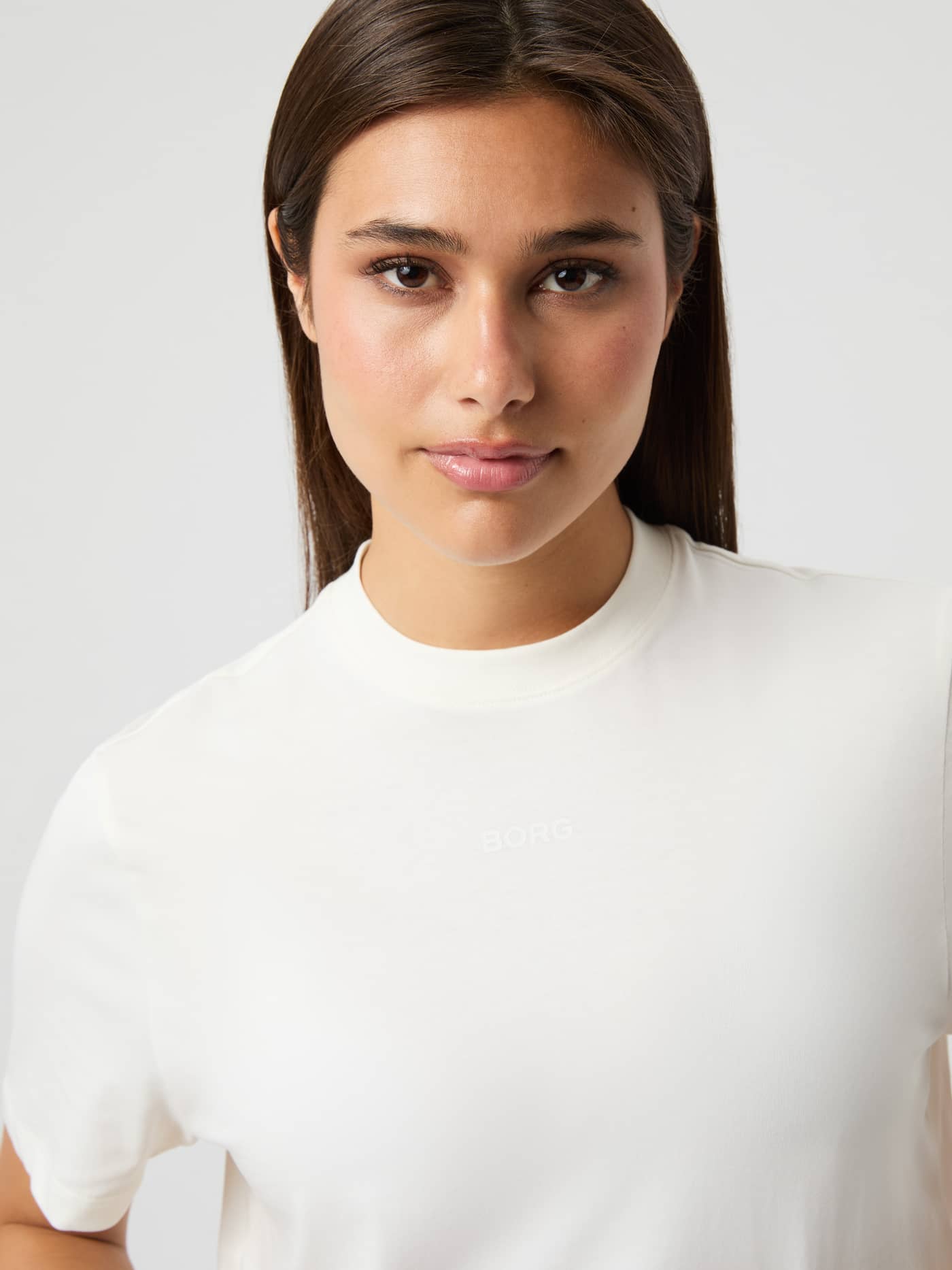 Close-up van het Studio Oversized Cropped T-Shirt in Cannoli Cream (Wit) met een tonaal logo voor training. - Image 4