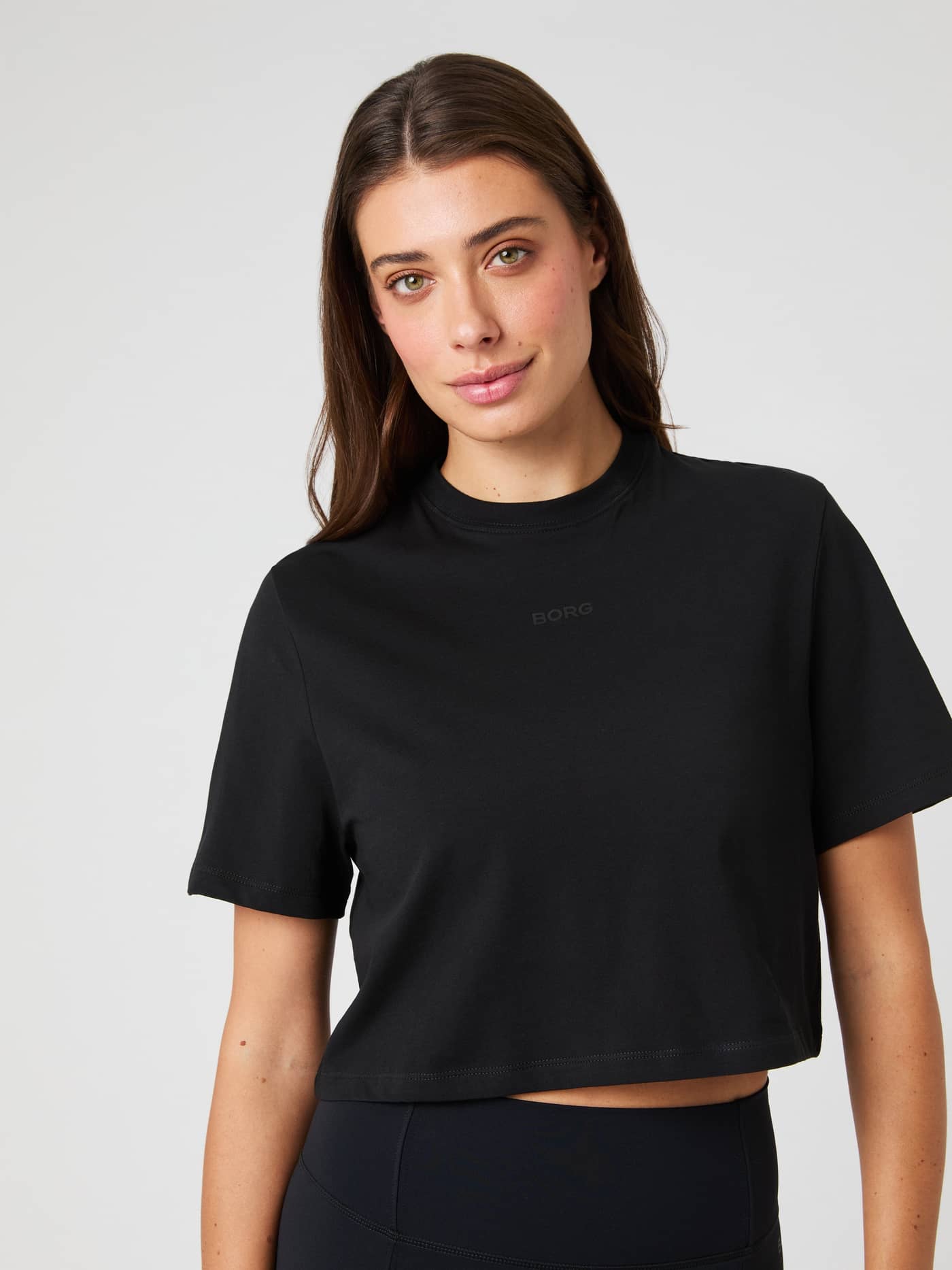 Front view of a woman wearing the cotton Björn Borg Studio Oversized Cropped T-Shirt in Black Beauty (Black) for training. - Image 4