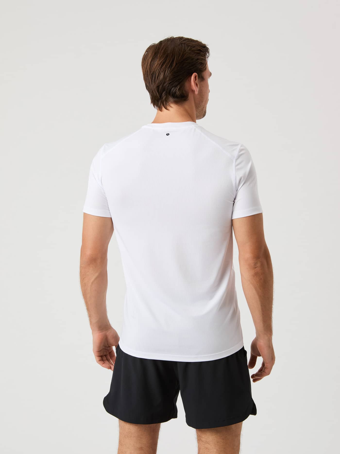 Back view of a man wearing the breathable Björn Borg Airy T-Shirt in Brilliant White (White) with a black logo for training. - Image 2