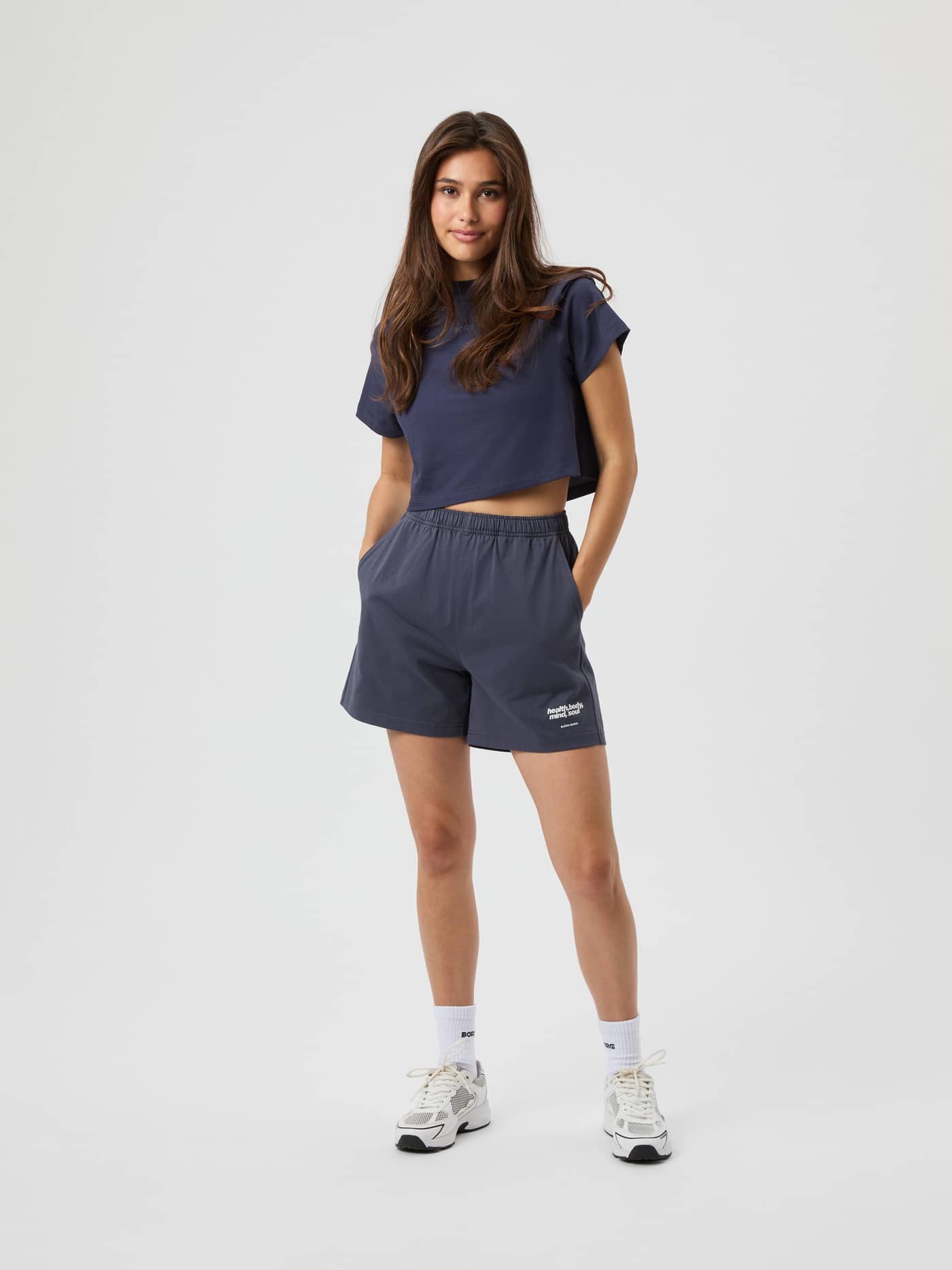 Studio Jersey Shorts i Odyssey Gray (Grå) set forfra på en kvinde i blød bomuld med hvidt logo og løs pasform. - Image 2