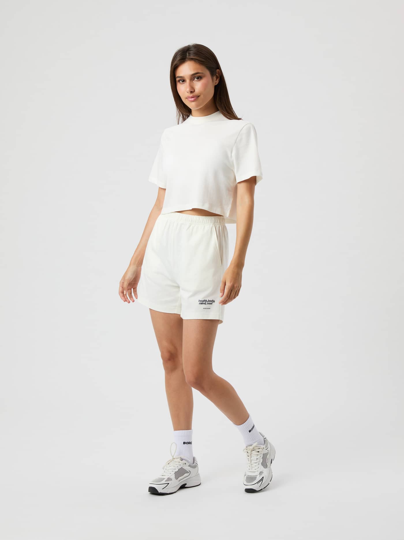 Vue de face d'une femme portant le Studio Jersey Shorts en coton Cannoli Cream (Blanc) avec une coupe taille haute. - Image 4