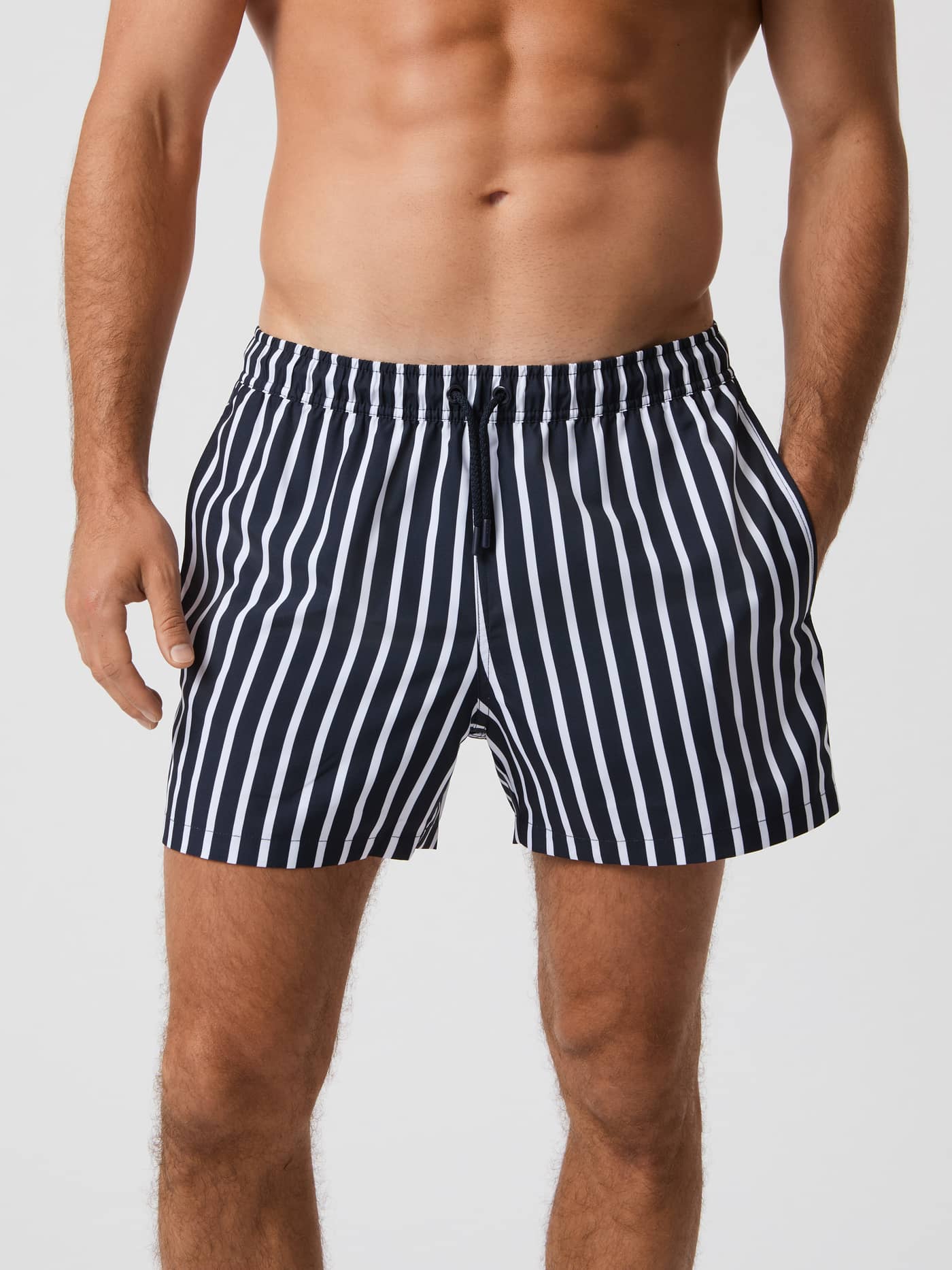 Front view of a man wearing the loose fit Björn Borg Print Swim Shorts in Wide Stripe 1 (multi) with a drawstring waist. - Image 1