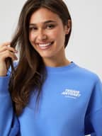 Close-up of the oversized Borg Boyfriend Sweatshirt in Ultramarine (Blue) featuring a tennis graphic print.