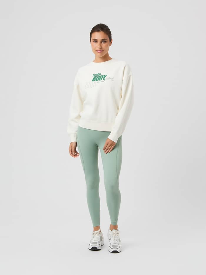 Ganzkörper-Vorderansicht einer Frau im oversized Borg Boyfriend Sweatshirt in Cannoli Cream (Weiß) mit Grafikprint. - Image 3