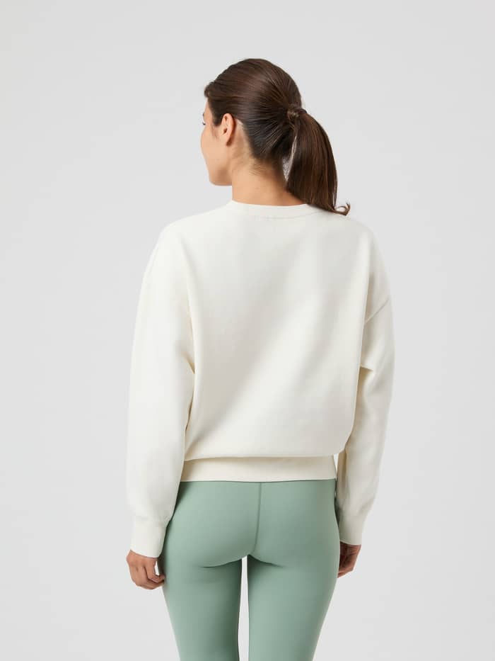 Rückansicht einer Frau im übergroßen Borg Boyfriend Sweatshirt in Cannoli Cream (Weiß) mit überschnittenen Schultern. - Image 5