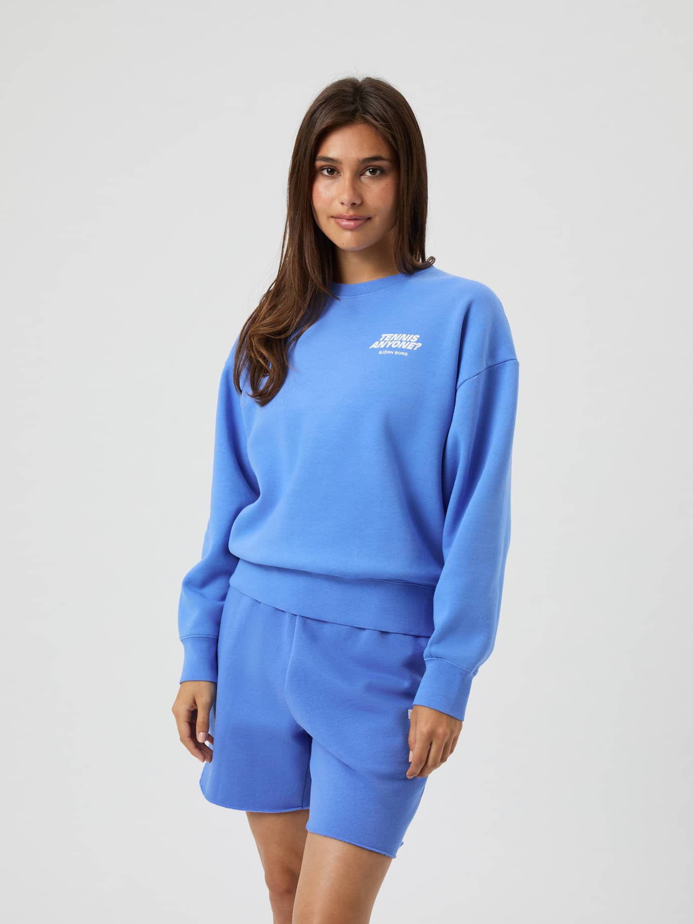 Vorderansicht einer Frau im übergroßen Borg Boyfriend Sweatshirt in Ultramarine (Blau) mit weißem Tennis-Grafikprint. - Image 2