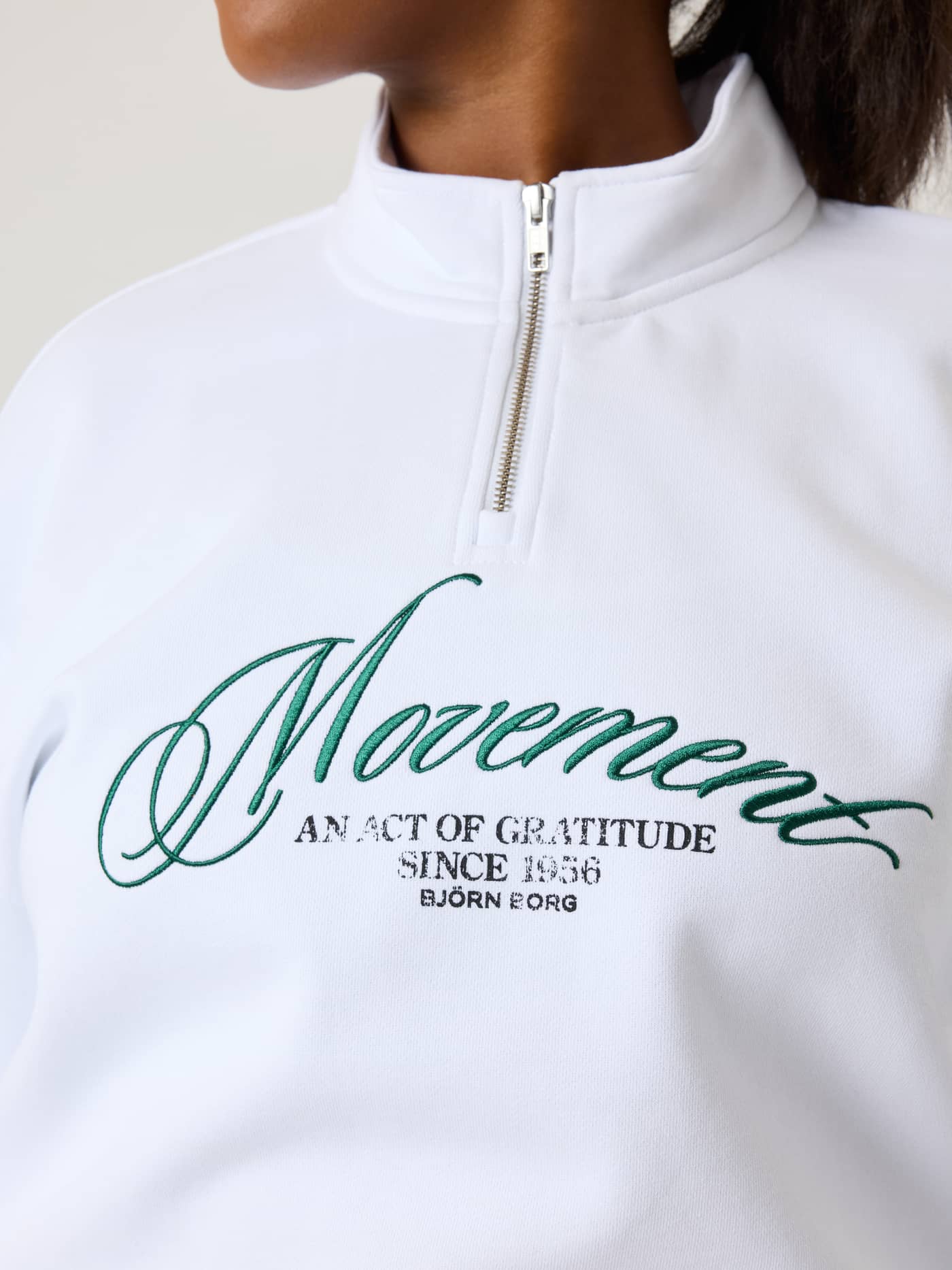Gros plan de l'Alice Stenlöf Halfzip Sweatshirt en Brilliant White (Blanc) avec graphisme Movement vert. - Image 9