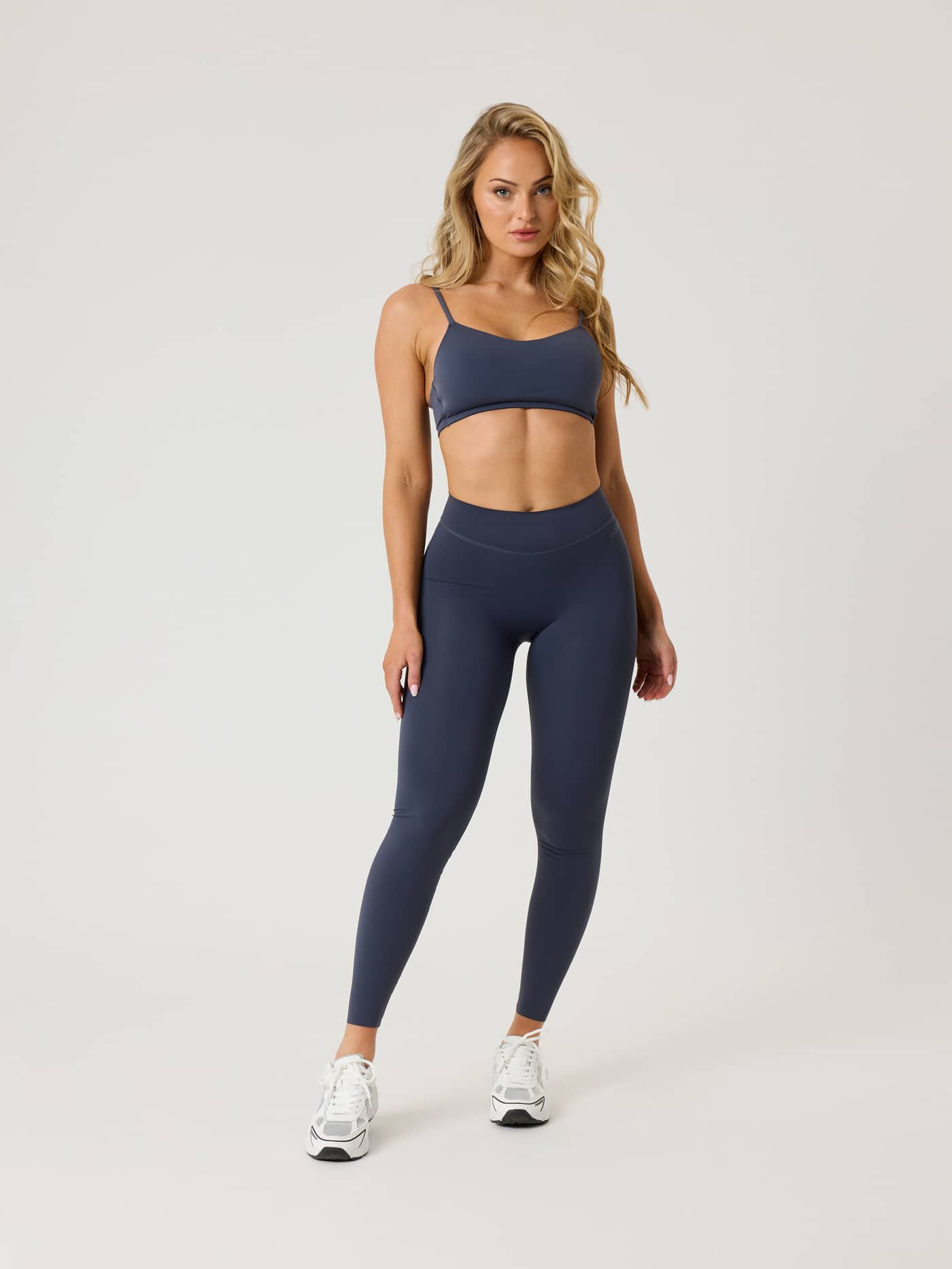 Front view of a model in flexible, high-waisted Alice Stenlöf Soft Tights in Odyssey Gray (Navy) for training. - Image 1