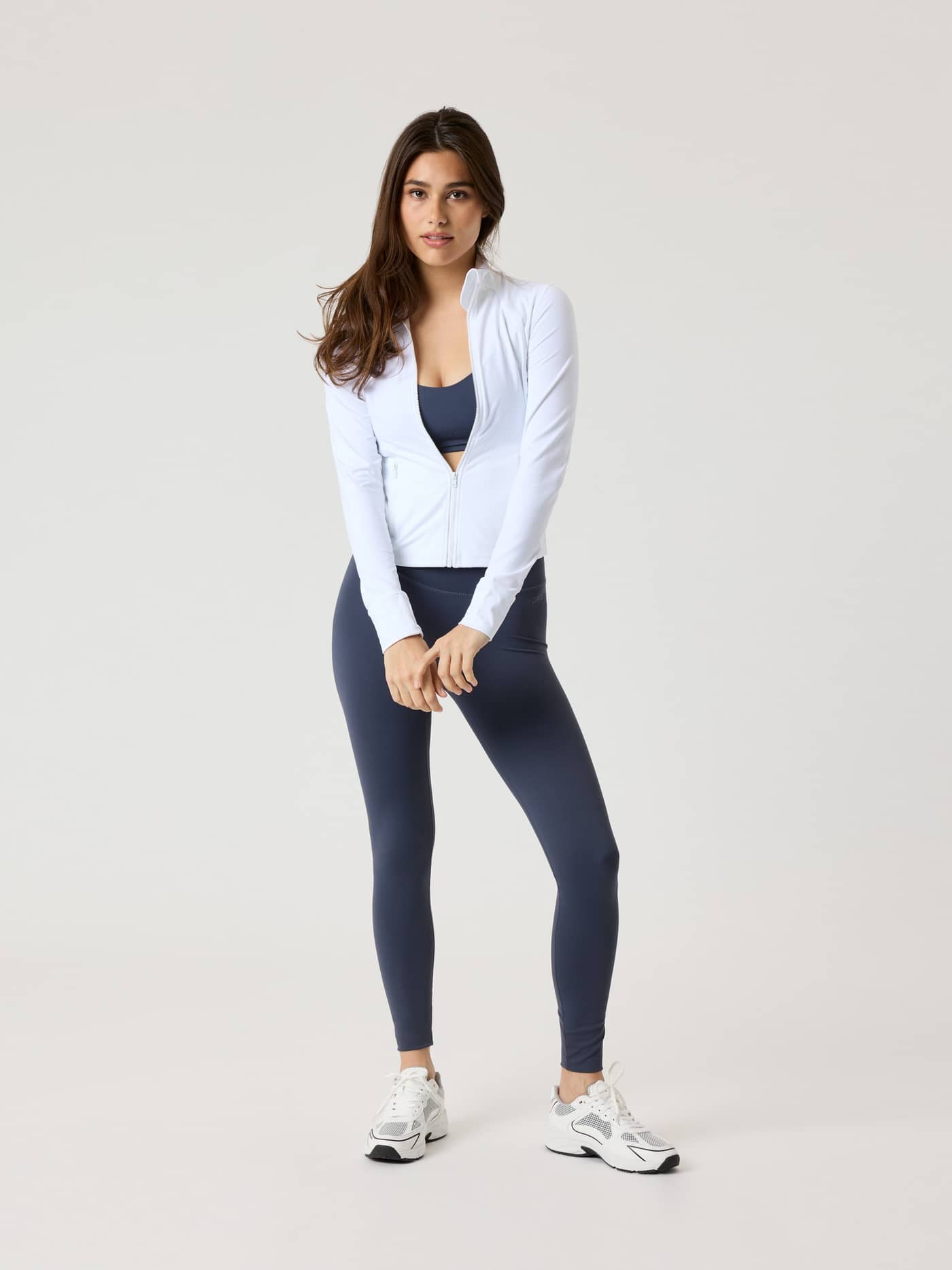 Front view of a woman in the slim fit Björn Borg Alice Stenlöf Soft Zip Midlayer in Brilliant White (White) for training. - Image 10