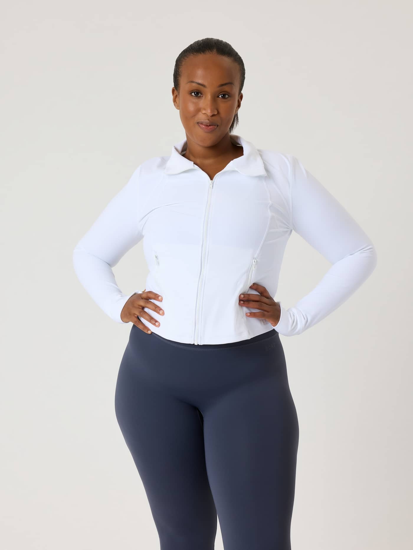 Front view of a model wearing the slim-fit Alice Stenlöf Soft Zip Midlayer in Brilliant White (White) for training. - Image 11